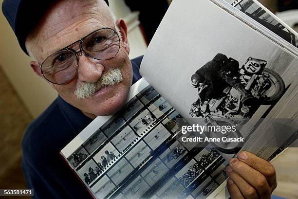 Stunt man Cliff Coleman holds the book with a photo of himself. A book signing for the book 40 Summers Ago written about Steve McQueen was held at...