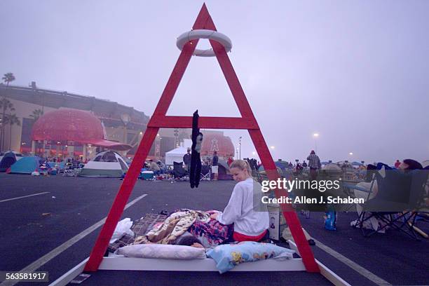 The Angels Rally Monkey hangs under a makeshift litup halo and wooden Angels sign as Stephanie Christmas of Riverside, right, tries to rouse her...