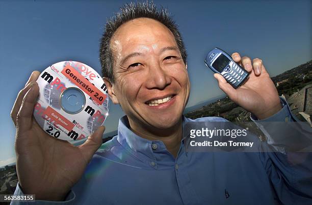 Gene Wang, Chairman and CEO of Bitfone Corp., holds a the software his company produces for use with cellphones. His Laguna Niguel software company...
