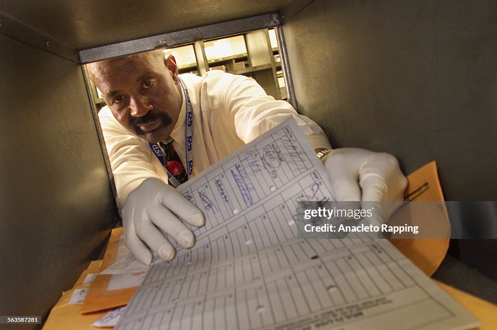 Glover Keetin, Supervisor of Mail Services for the Los Angeles County government offices, wears rubb