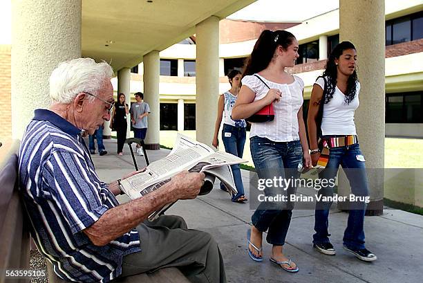 Stan Peters, left, reads up on Jewish news while freshmen tour the campus of the New Community Jewish High School during a student orientation day...