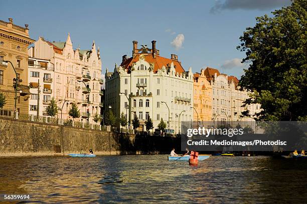 low angle view of buildings on the banks of a river, vltava river, prague, czech republic - río vltava fotografías e imágenes de stock