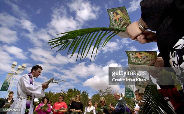 Irvine, April 13, 2003  Rev. Steven Borst , left, holds prayers before leading the procession into the church for second part of two part "Passion...