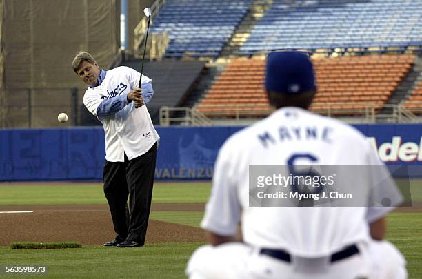 Ryder Cup captain Hal Sutton, chips the first pitch to new catcher Brent Mayne at Dodger Stadium Tuesday night August 3, 2004 before the start of the...