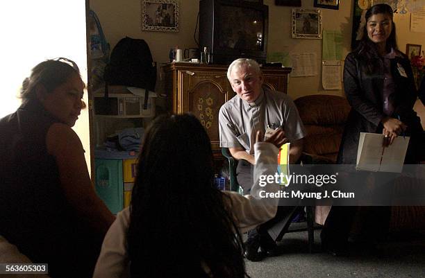 Father Jarlath "Jay" Cunnane of St. Thomas the Apostle Church and parishioner Balbina Hernandez meet with Irene Antonio and daughter Ruby Hernandez...