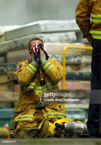 Compton Firefighter Sean Halvorson dropped to his knees for a rest and wiped his face with a patriotic bandana as he and others battled a stubborn...