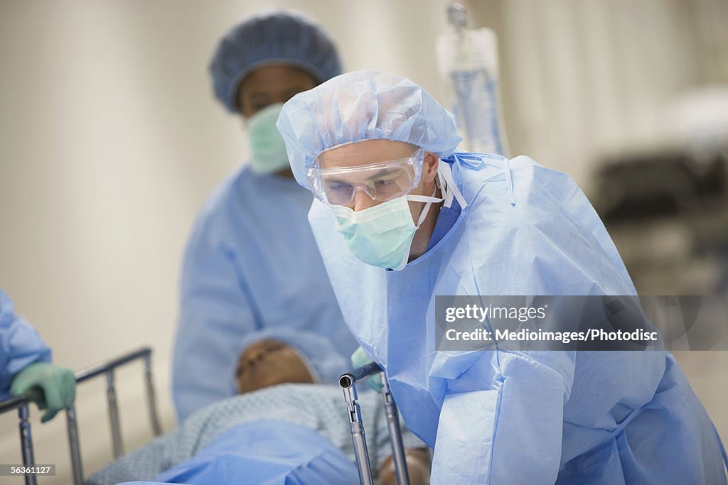 Surgical team rolling patient down corridor to surgery