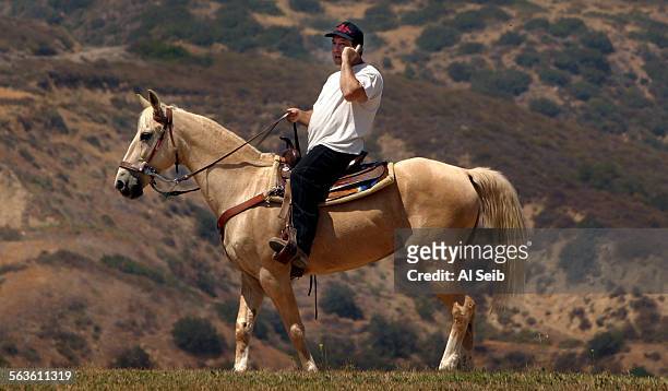 Can You Hear Me Now ? Howard Reinstein, 45 years old of Lake Balboa area, is aboard his Quarterhorse Ginger as he rides to the top of Porter Ridge...