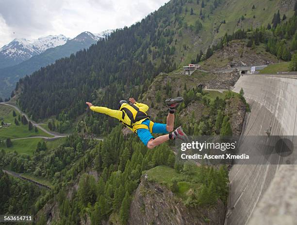 base jumper in free fall down face of concrete dam - base jumping imagens e fotografias de stock