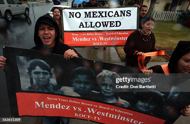 Hector Flores, a student at Long Beach State Univ. Is among about 50 people marching through the rain from a the site of Hoover Elementary in...