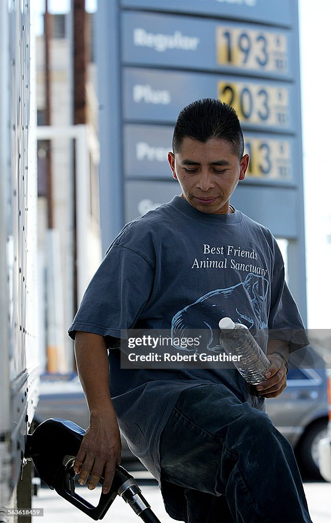 Moses Patzan pumps gas at a downtown Los Angeles Shell station where prices hovered around $2, Thurs