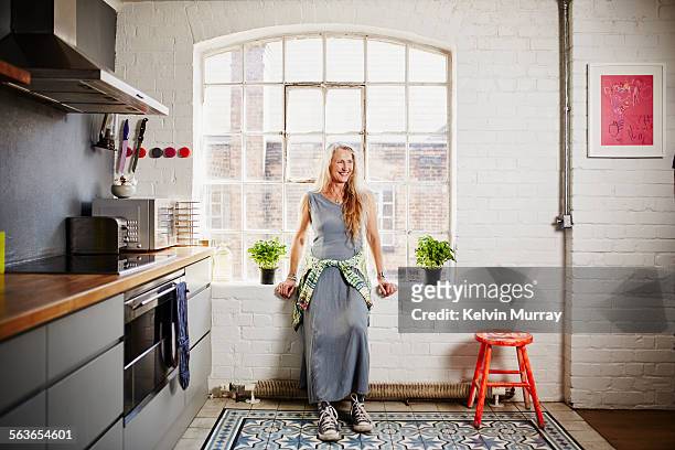 a shot of funky older woman standing in kitchen - küche modern stock-fotos und bilder