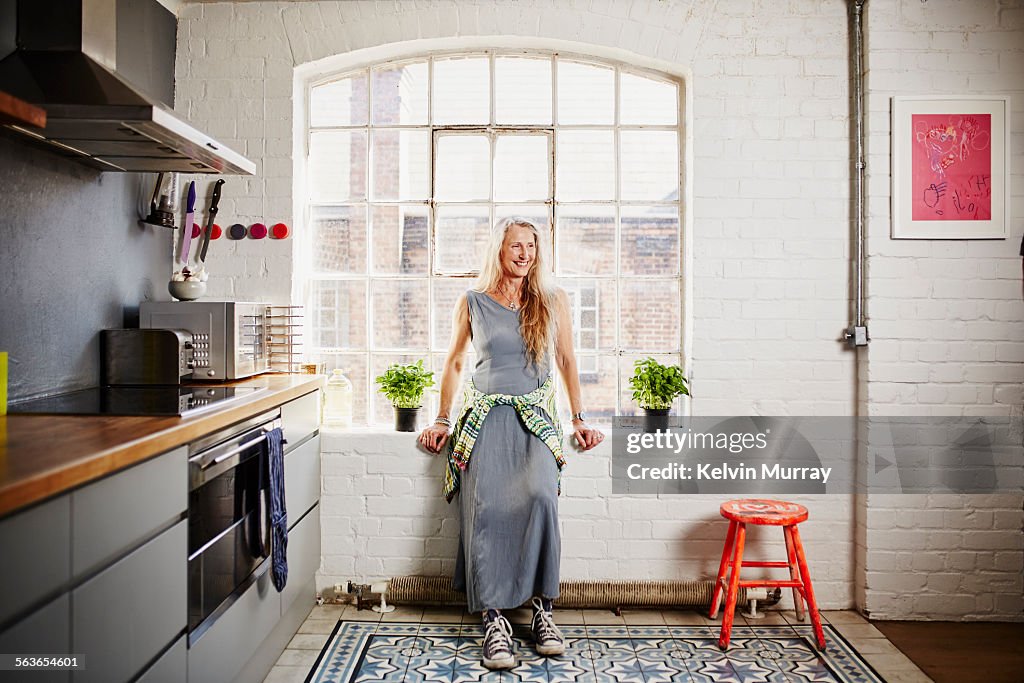 A shot of funky older woman standing in kitchen