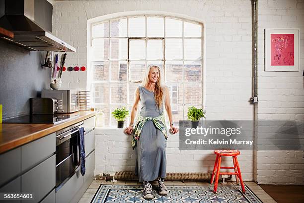 a shot of funky older woman standing in kitchen - middle aged woman at home stock pictures, royalty-free photos & images