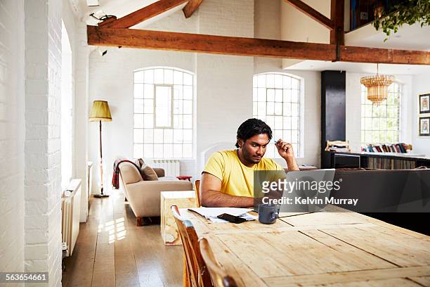a guy working from home on a sunny day - indian living room stock pictures, royalty-free photos & images
