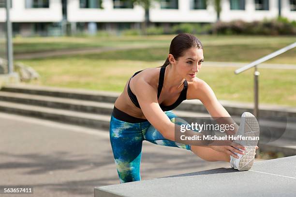 woman doing hamstring stretch - tendine del ginocchio foto e immagini stock