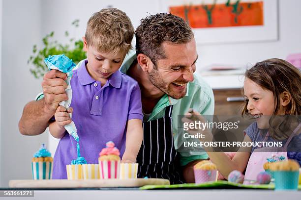 single father is baking with his kids - cupcakes girls fotografías e imágenes de stock