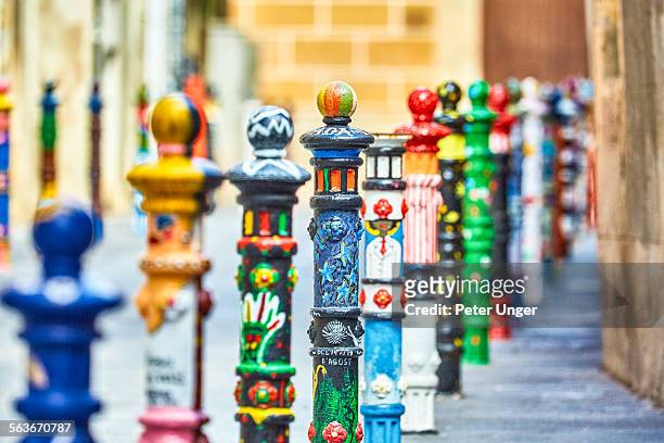 colourful parking bollards in street, tarragona - street art around the world stock pictures, royalty-free photos & images