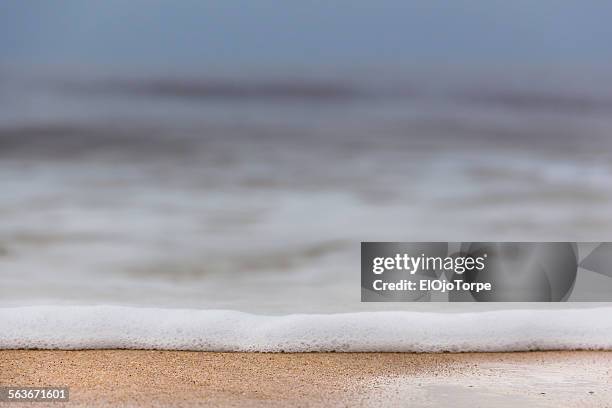 close-up of little wave in the beach, sand, foam - canelones ストックフォトと画像