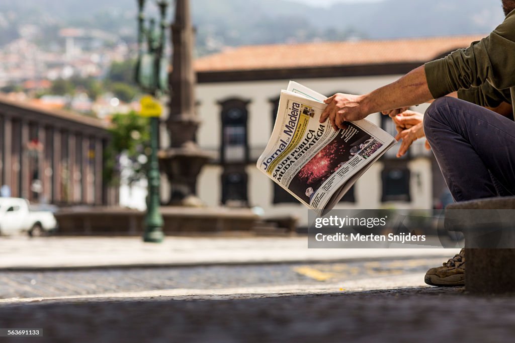Hand holding a Madeira newspaper on square