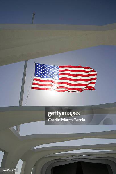 Flag flies at half mast aboard the USS Arizona Memorial during the ceremony honoring the 64th anniversary of the surprise attack on Pearl Harbor,...