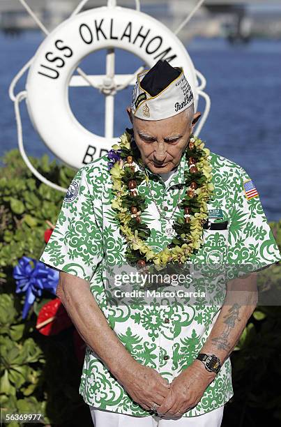 After laying a memorial wreath, USS Oklahoma and Pearl Harbor survivor Sterling Cale bows his head in prayer during the ceremony honoring the 64th...