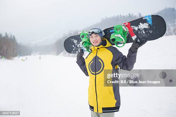 young man with snowboard on the snow - harbin winter - fotografias e filmes do acervo