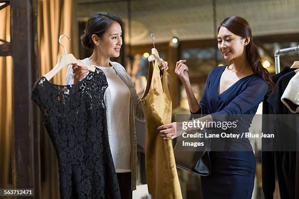 clothing store owner helping customer with choosing dress - clothes customization stockfoto's en -beelden