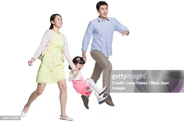 happy young family holding hands running - man pulling object fotografías e imágenes de stock