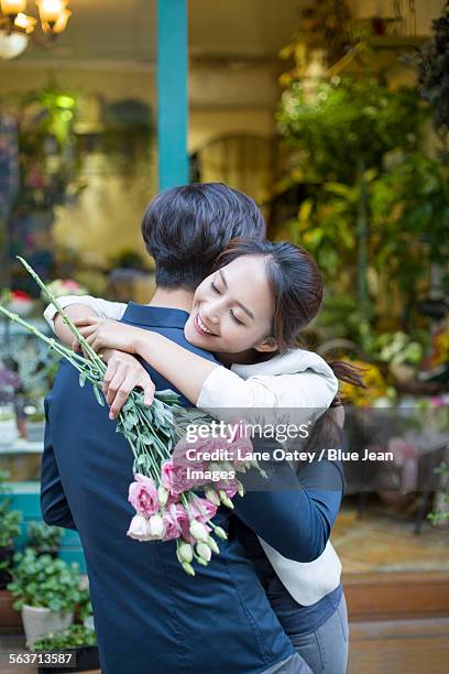 young woman embracing boyfriend with flowers - asia lady selling flower stock pictures, royalty-free photos & images