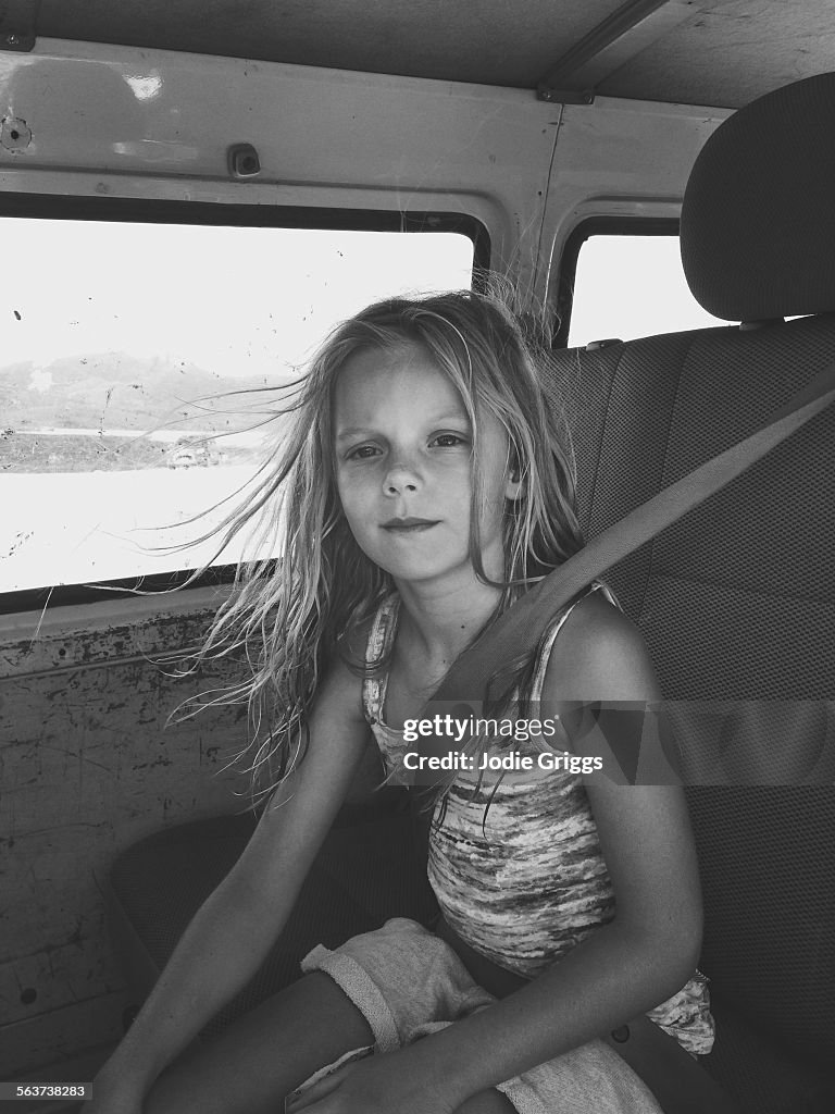 Child sitting in the back of car wearing seat belt