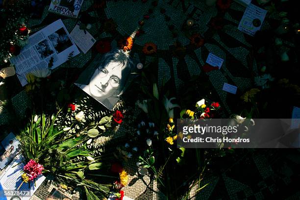 Picture of slain pop singer and activist John Lennon lies among flowers and memorabilia in Strawberry Fields, a memorial area to him in Central Park...