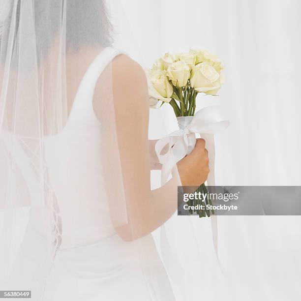 rear view of a bride holding a bouquet of flowers - white dress back stock pictures, royalty-free photos & images