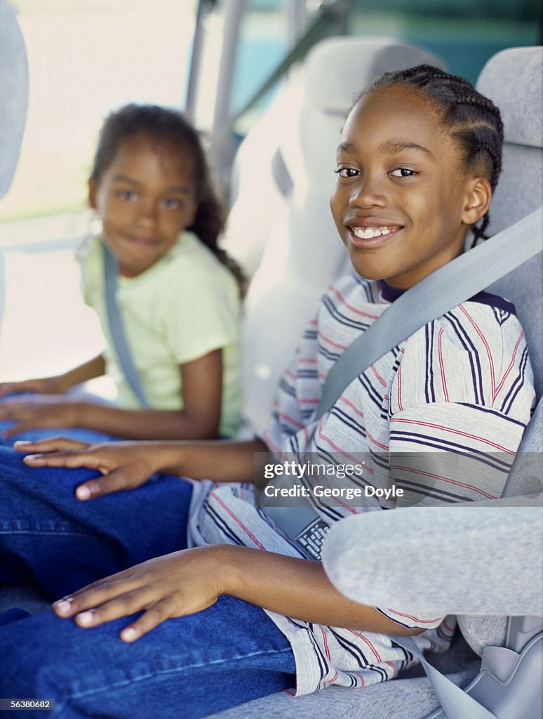 Portrait of a brother and his sister in the back seat of a car