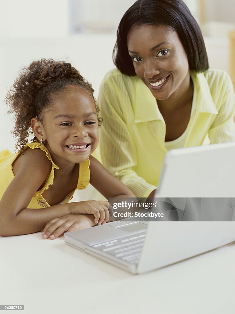 Portrait of a mother and her daughter using a laptop