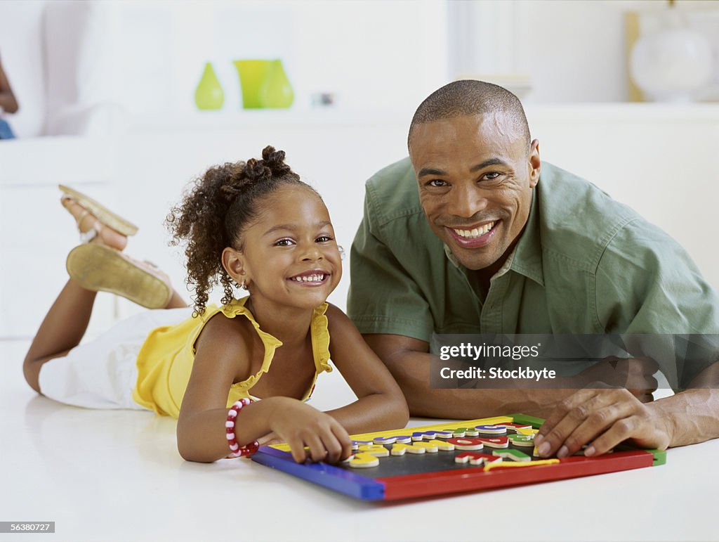 Portrait of a father and his daughter playing a board game