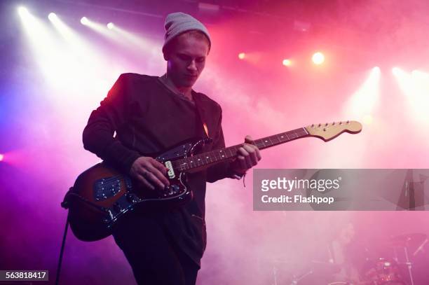 guitarist performing on stage at music concert - guitarrista fotografías e imágenes de stock