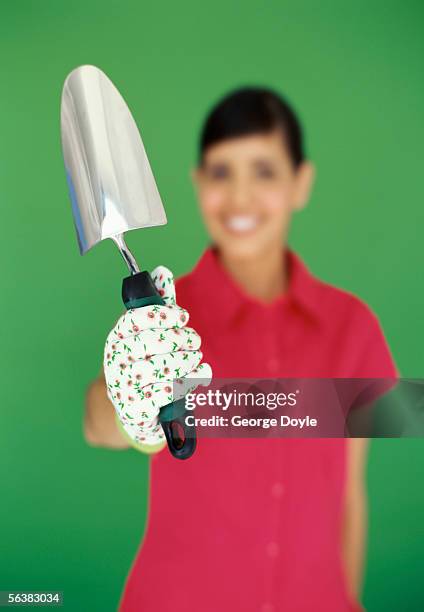 portrait of a young woman holding a spade - garden trowel stock pictures, royalty-free photos & images