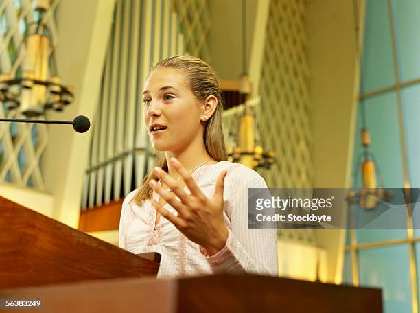low angle view of a teenage girl speaking in a church - pulpit stock-fotos und bilder