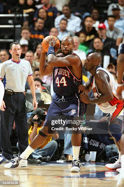 Marc Jackson of the New Jersey Nets is defended by Adonal Foyle of the Golden State Warriors during the game at the Arena in Oakland on November 21,...