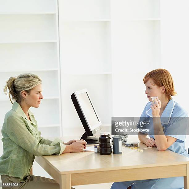 side profile of a nurse sitting with a patient - patient profile stock pictures, royalty-free photos & images