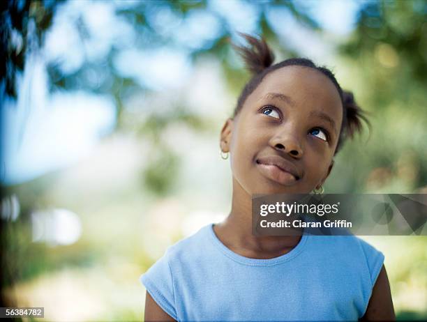 close-up of a girl looking up - kid thinking stock-fotos und bilder
