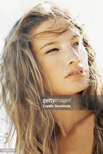 close-up of a young woman looking sideways - entrecerrar los ojos fotografías e imágenes de stock