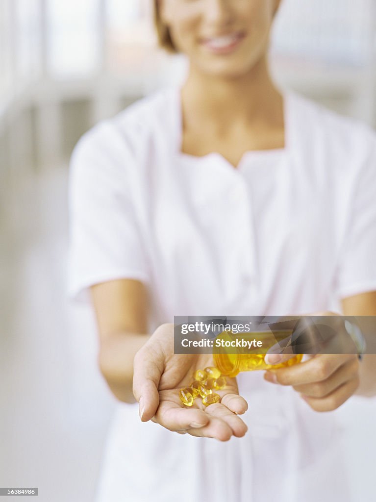 Female nurse showing cod liver oil pills
