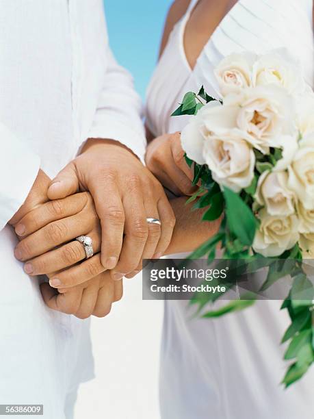 mid section view of a newlywed couple holding hands - mid section stock pictures, royalty-free photos & images