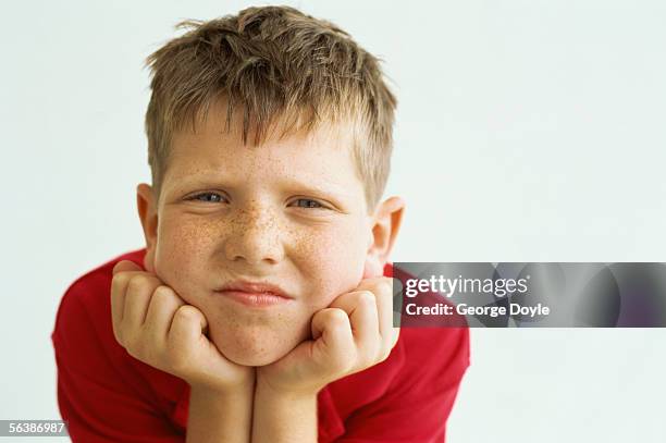 portrait of a boy with his hands under his chin - bube stock-fotos und bilder