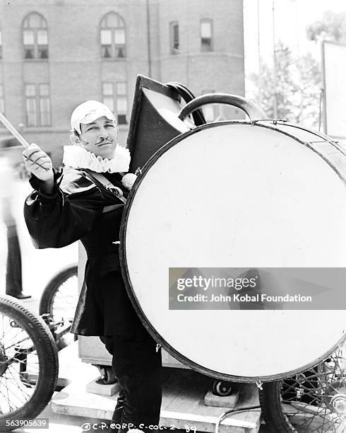 Actor Bing Crosby banging a huge drum as he films scenes for the movie 'Pennies from Heaven', for Columbia Pictures, 1936.