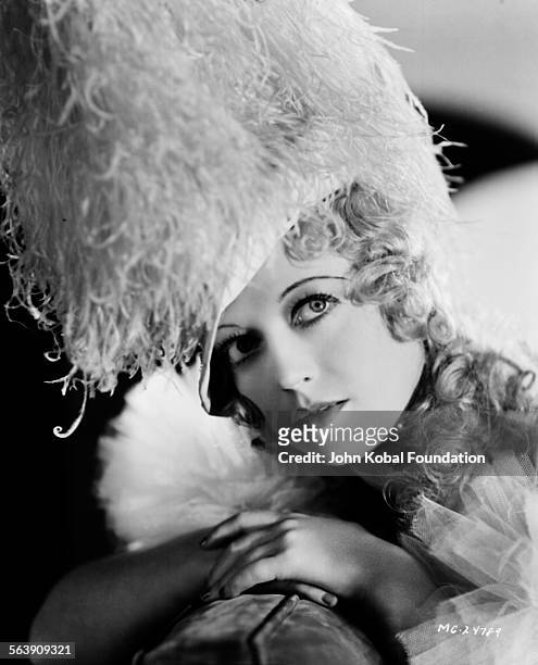 Portrait of actress Marion Davies wearing a large feather headdress, for MGM Studios, July 9th 1932.