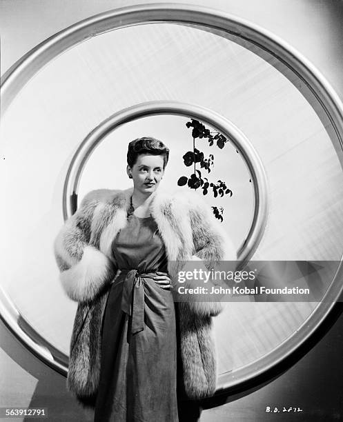 Portrait of actress Bette Davis wearing a fur coat, as she appears in the film 'Now Voyager', for Warner Bros Studios, 1942.