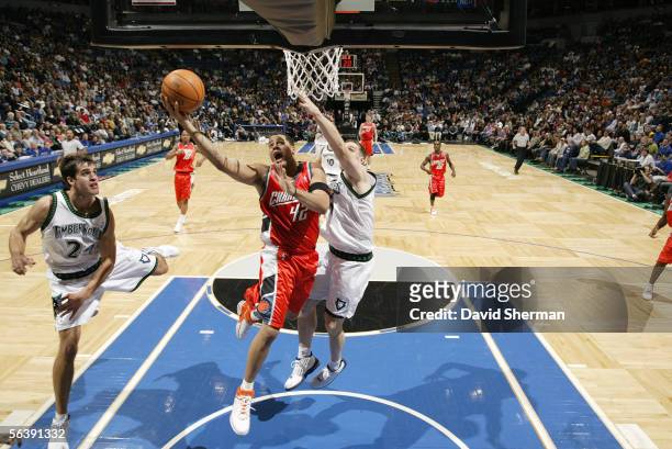 Sean May of the Charlotte Bobcats goes up for a layup between Richie Frahm and Mark Madsen of the Minnesota Timberwolves during a game at Target...